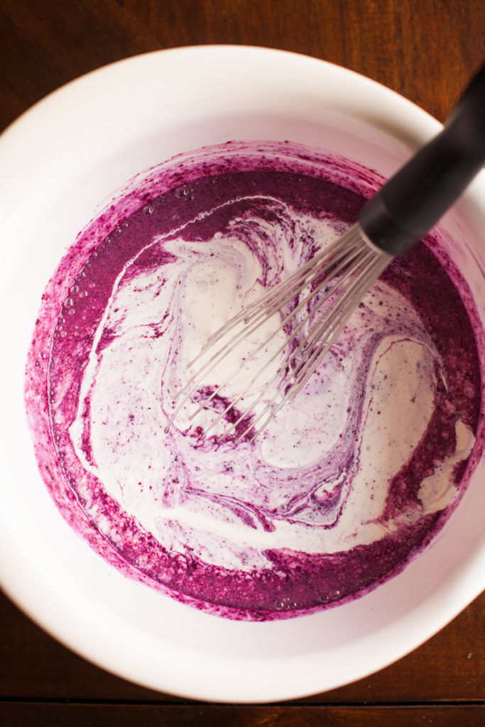 Whole milk added to blueberry puree and sugar for blueberry ice cream.