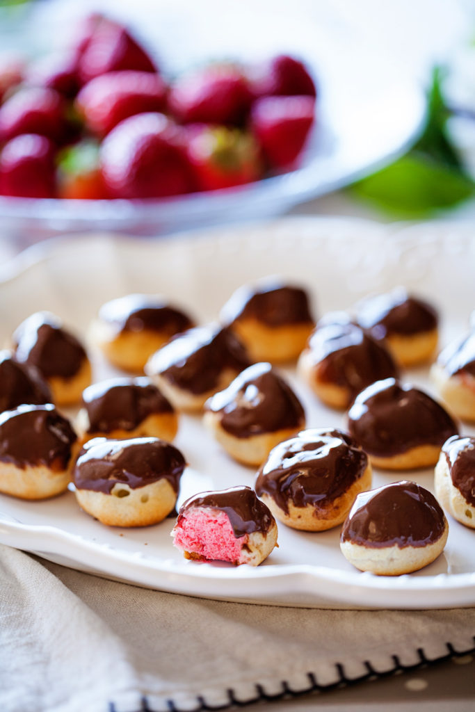 Want to learn how to make Strawberry Cream Puffs? It's really easy and makes such an impressive dessert! Cream puffs, strawberry chocolate covered cream puffs, strawberry chocolate cream puffs