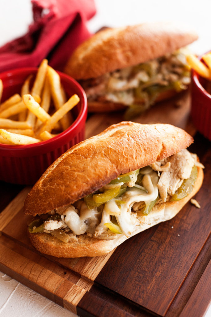 Chicken Philly Cheesesteak Sandwiches with French fries.