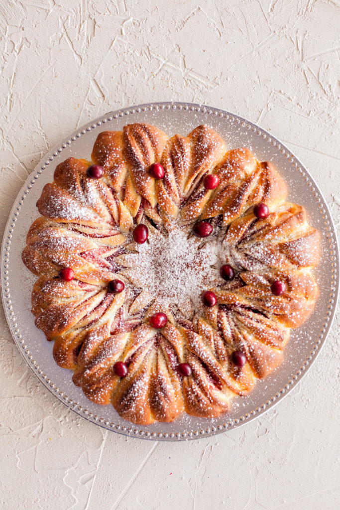 Star Bread with cranberry filling topped with powdered sugar and fresh cranberries.