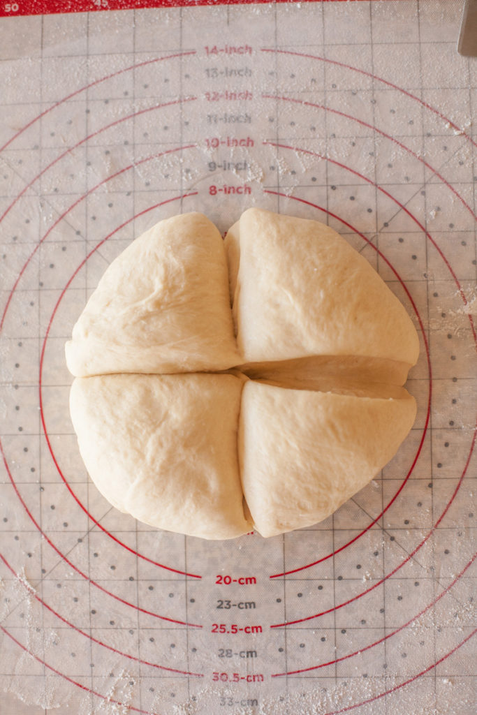 Bread dough cut into four equal pieces.
